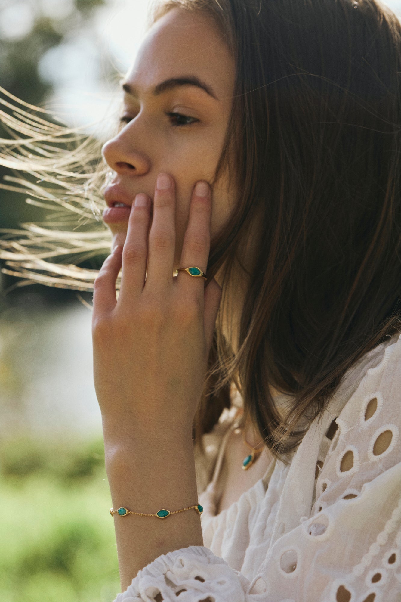 Woman wearing a amazonite ring and bracelet with a blurred natural background