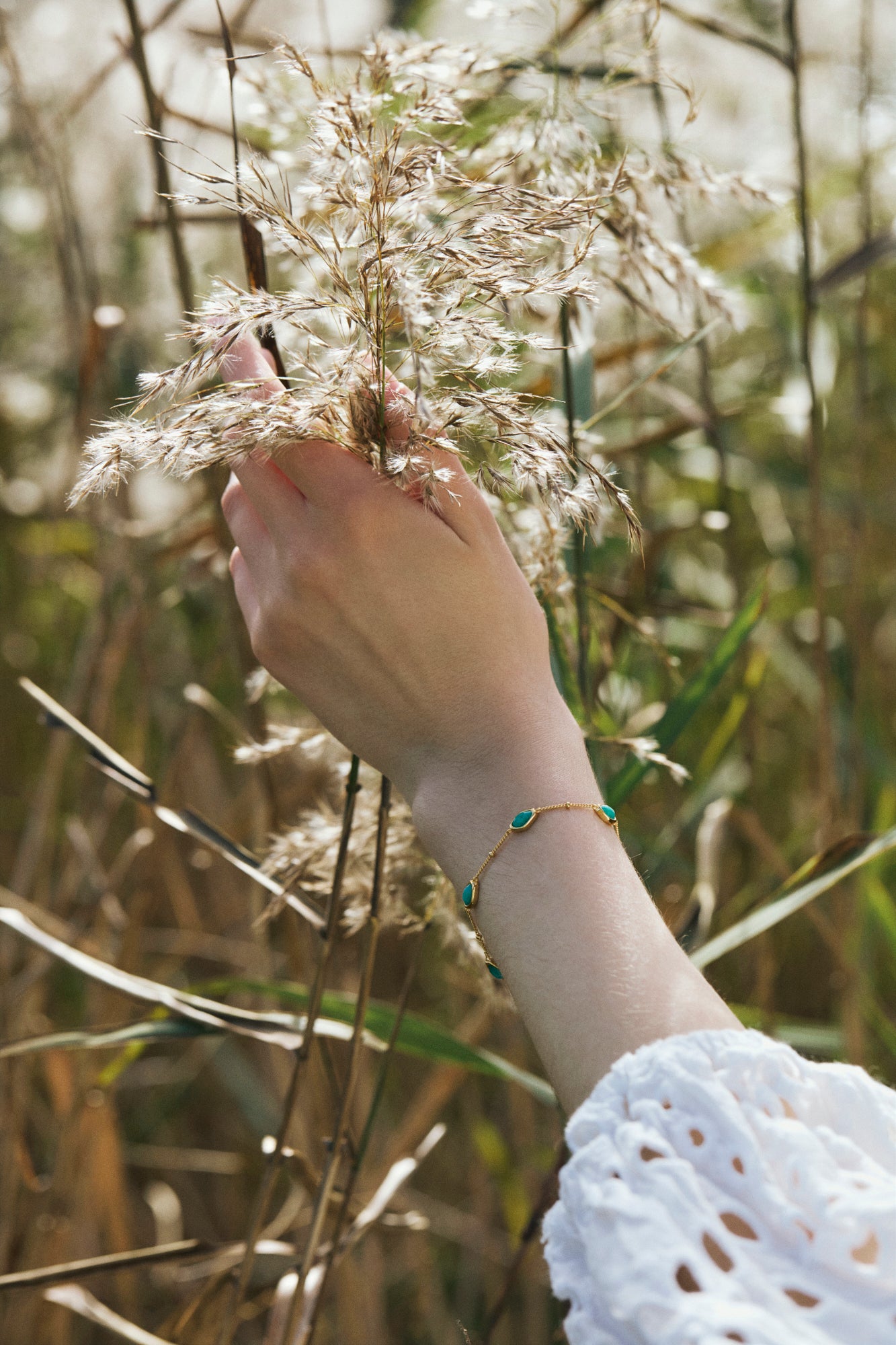 Hand wearing gold amazonite bracelet 